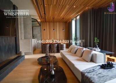 Modern living room with wooden ceiling, large couch, and coffee table