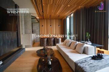 Modern living room with wooden ceiling, large couch, and coffee table