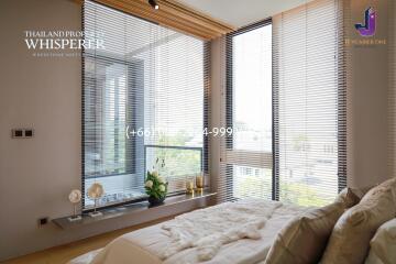 Modern bedroom with large windows and city view