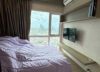 Cozy bedroom with a large window view of the city