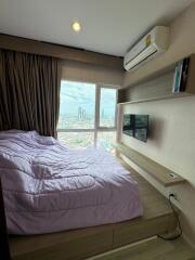 Cozy bedroom with a large window view of the city