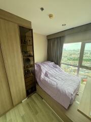 Cozy bedroom with a large window and city view