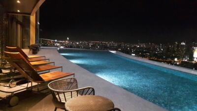 Rooftop infinity pool with city skyline view at night