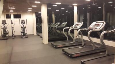 Modern fitness center with treadmills and elliptical machines