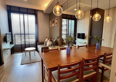 Modern living and dining area with wooden furniture and decorative lighting