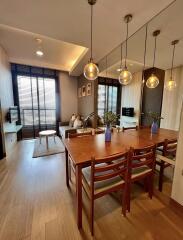 Modern living and dining area with wooden furniture and decorative lighting