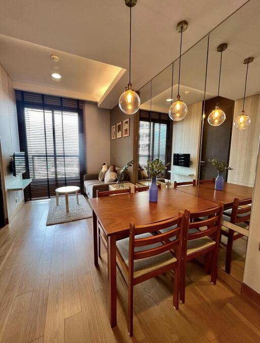 Modern living and dining area with wooden furniture and decorative lighting