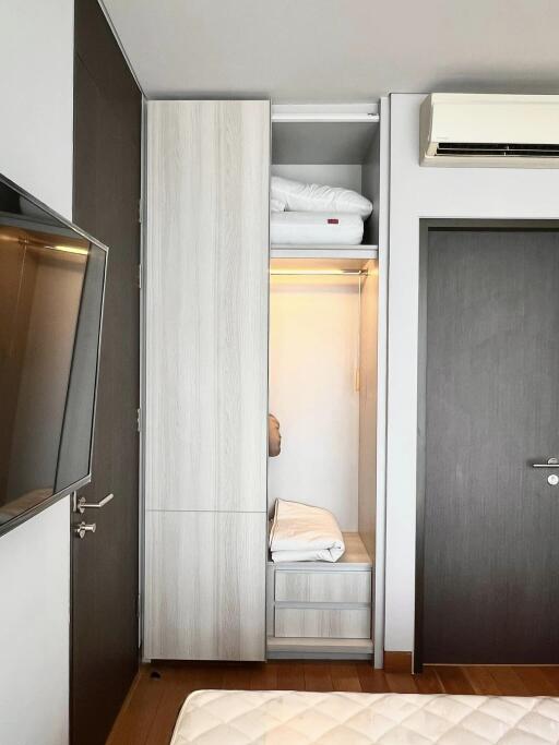 Bedroom with wardrobe, air conditioning unit, and wall-mounted TV