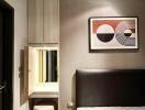 Bedroom with modern design featuring a wall-mounted art piece and vanity area