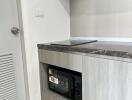 Modern kitchen area with built-in microwave and sleek cabinetry