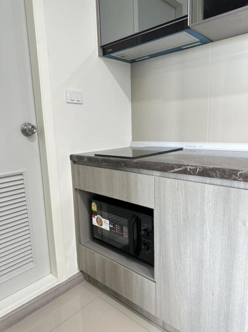 Modern kitchen area with built-in microwave and sleek cabinetry