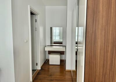 Vanity area in a modern bedroom with wooden floors and large mirror