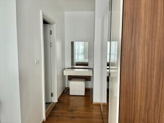 Vanity area in a modern bedroom with wooden floors and large mirror