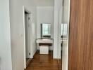 Vanity area in a modern bedroom with wooden floors and large mirror