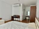 Bedroom with wooden flooring, study area, air conditioner and vanity