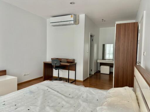 Bedroom with wooden flooring, study area, air conditioner and vanity