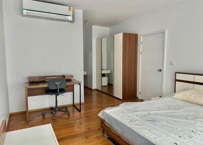 Furnished bedroom with desk, chair, wardrobe, air conditioning, and bed