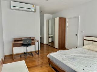 Furnished bedroom with desk, chair, wardrobe, air conditioning, and bed