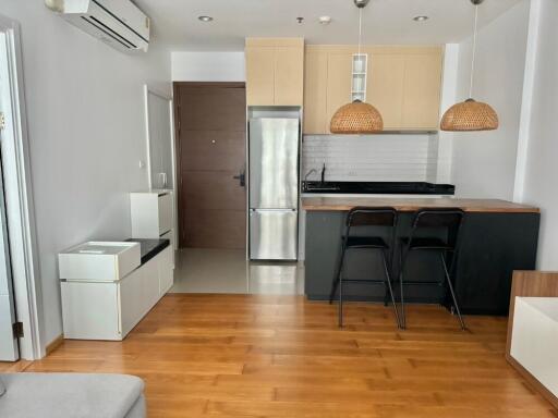 Modern living room with adjoining kitchen and wooden flooring