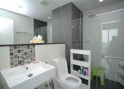 Modern bathroom with sink, toilet, and shower area