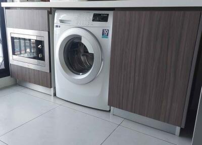 Laundry area with washing machine and built-in microwave