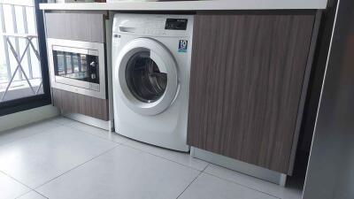 Laundry area with washing machine and built-in microwave