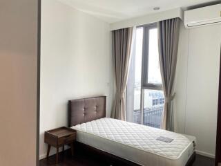 Bedroom with large window and twin bed