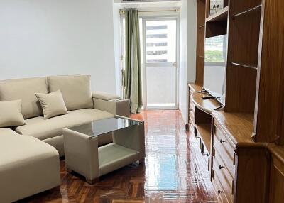 Living room with sofa, coffee table, and built-in wooden shelves