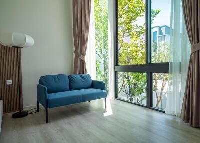 Living room with blue sofa and large window with curtains