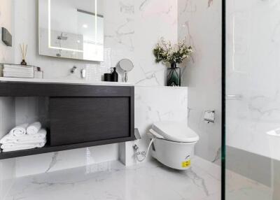 Modern bathroom with vanity, toilet, and floral decoration