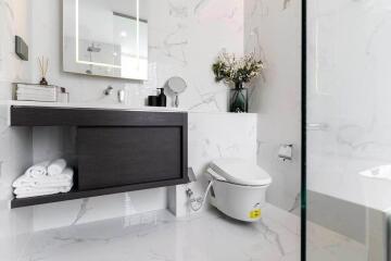 Modern bathroom with vanity, toilet, and floral decoration