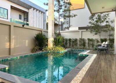 Luxury outdoor pool with modern fencing and greenery