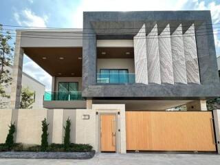 Modern two-story house with large balcony and distinctive facade