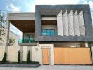 Modern two-story house with large balcony and distinctive facade