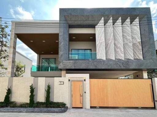 Modern two-story house with large balcony and distinctive facade