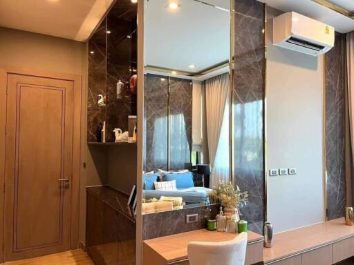 Modern bedroom with built-in shelving, wall-mounted air conditioner, and vanity mirror