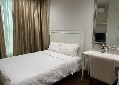 Modern bedroom with a bed, desk, and mirror