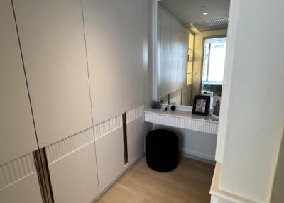 A hallway with built-in storage and a small vanity area