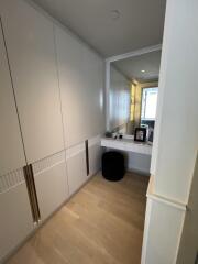 A hallway with built-in storage and a small vanity area