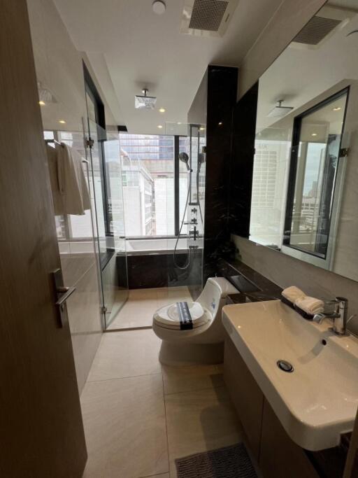 Modern bathroom with glass shower and city view