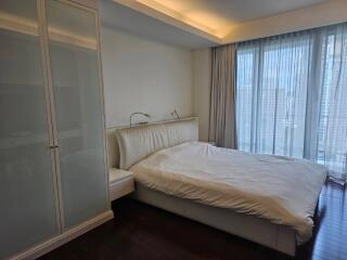 Modern bedroom with glass-door wardrobe and large windows