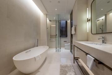 Modern bathroom with a freestanding bathtub, glass shower enclosure, and double sink vanity