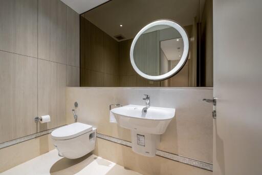 Modern bathroom with wall-mounted toilet, sink, and mirror