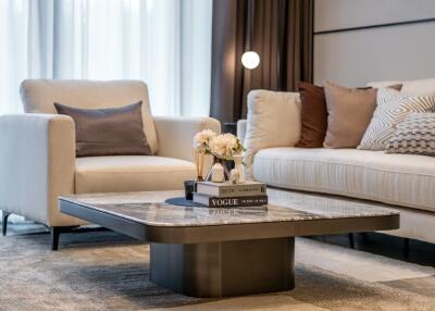 Modern living room with coffee table, armchair, sofa, and decorative items