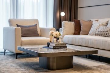 Modern living room with coffee table, armchair, sofa, and decorative items