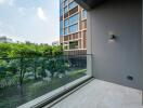 Balcony with glass railing and view of greenery