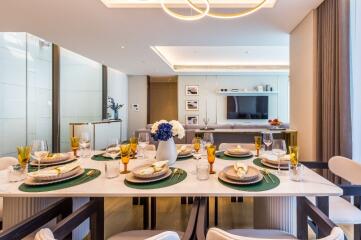 Modern dining room with a well-set table and a view into the living area