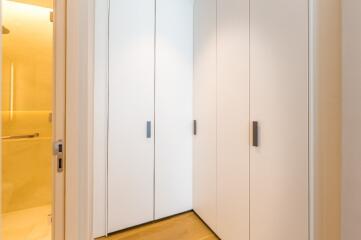 Spacious closet with white cabinets and wooden floor