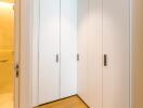 Spacious closet with white cabinets and wooden floor