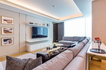 Modern luxurious living room with large sectional sofa and wall-mounted TV